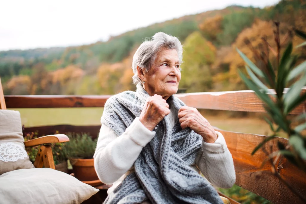 an elderly woman sitting outdoors on a terrace on 2022 02 02 03 48 38 utc